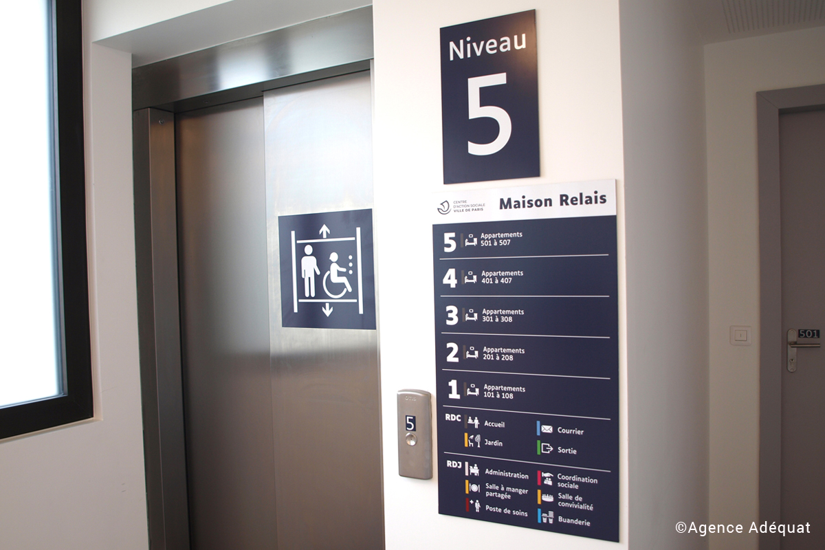 Sur la cabine de l'ascenseur, il y a un pictogramme, le numéro d'étage et le répertoire des services.